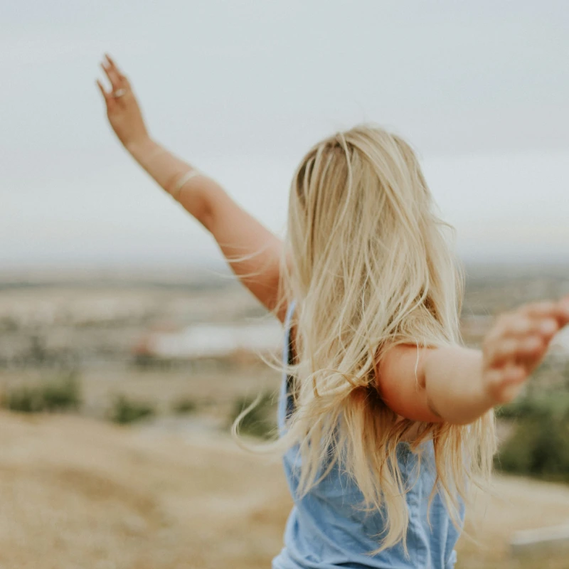 Back of a Female feeling happy with her hands in the air